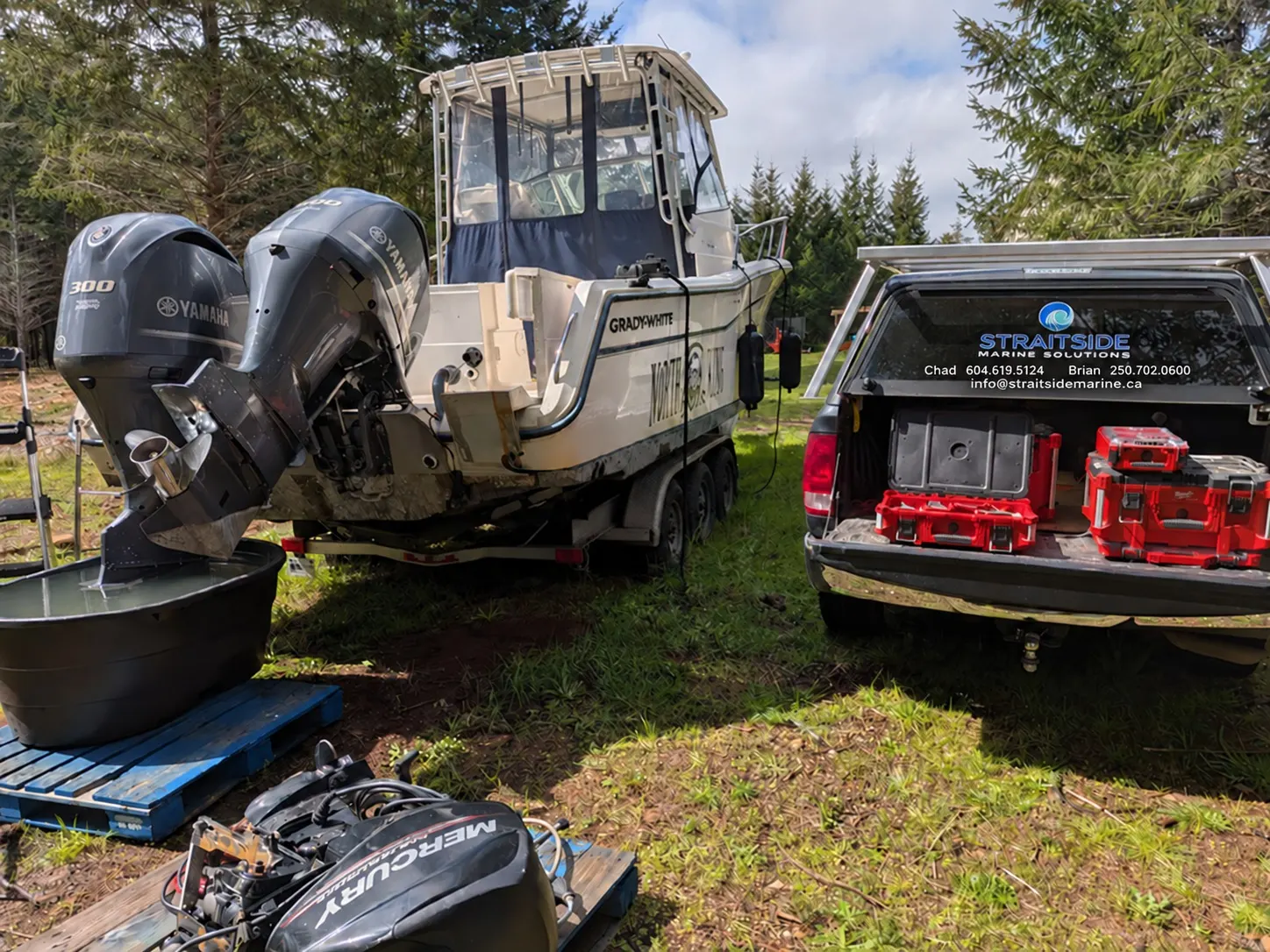 Straitside service truck beside a powerboat with twin outboard engines