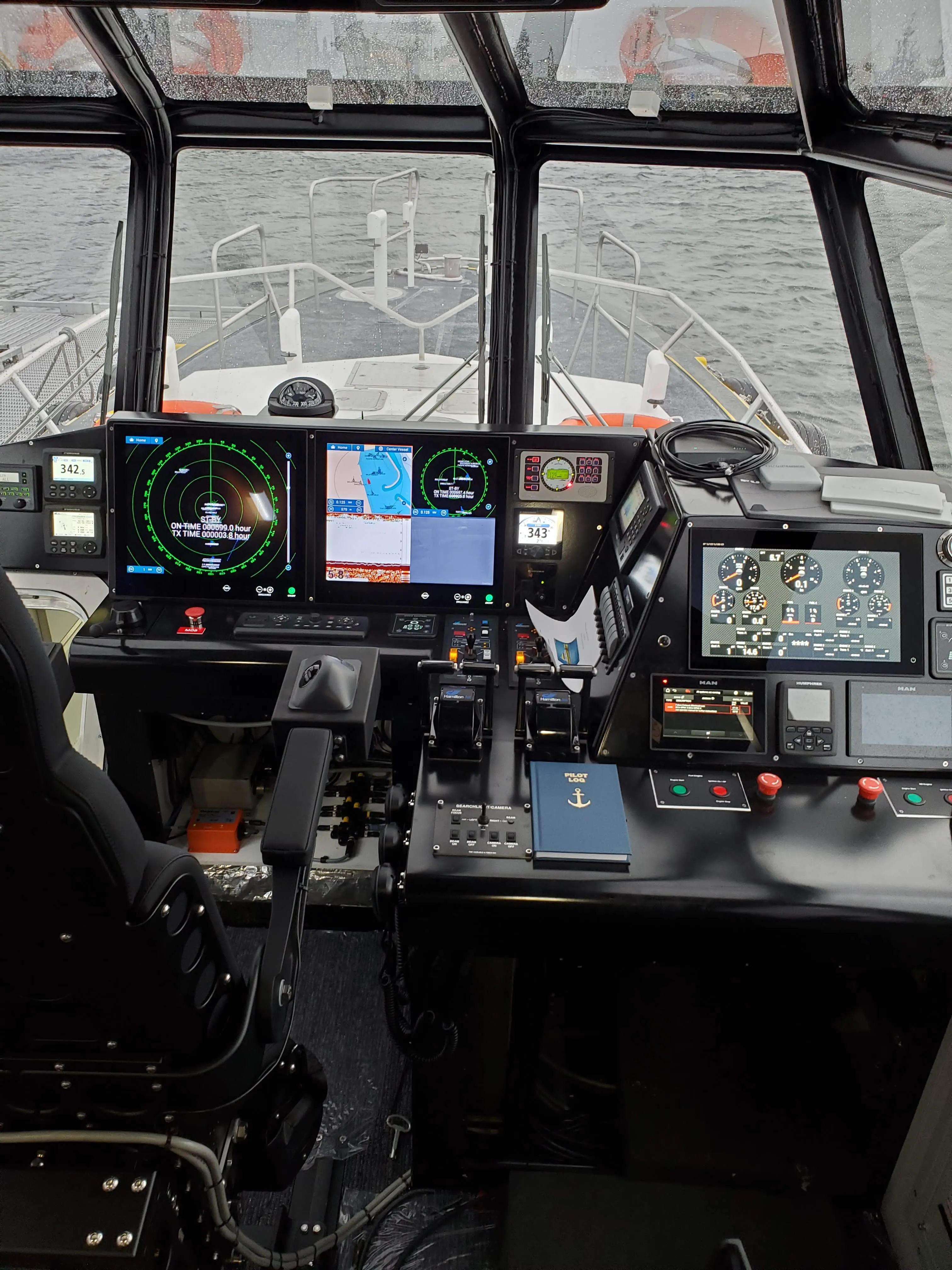 Wheelhouse of a commercial vessel with radar, chart plotter and engine displays