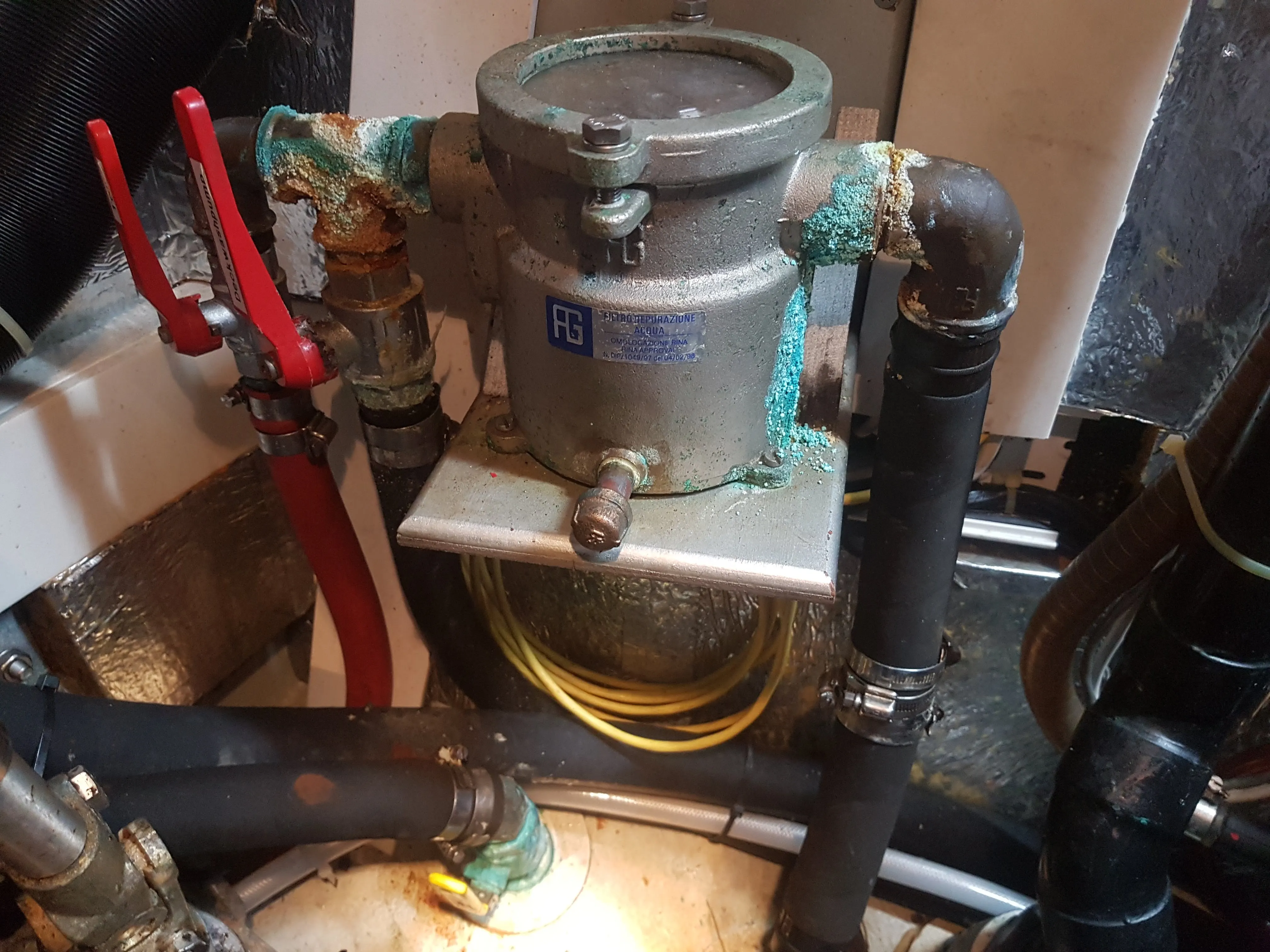 Raw-water strainer with valves, hoses and fittings in a vessel machinery space