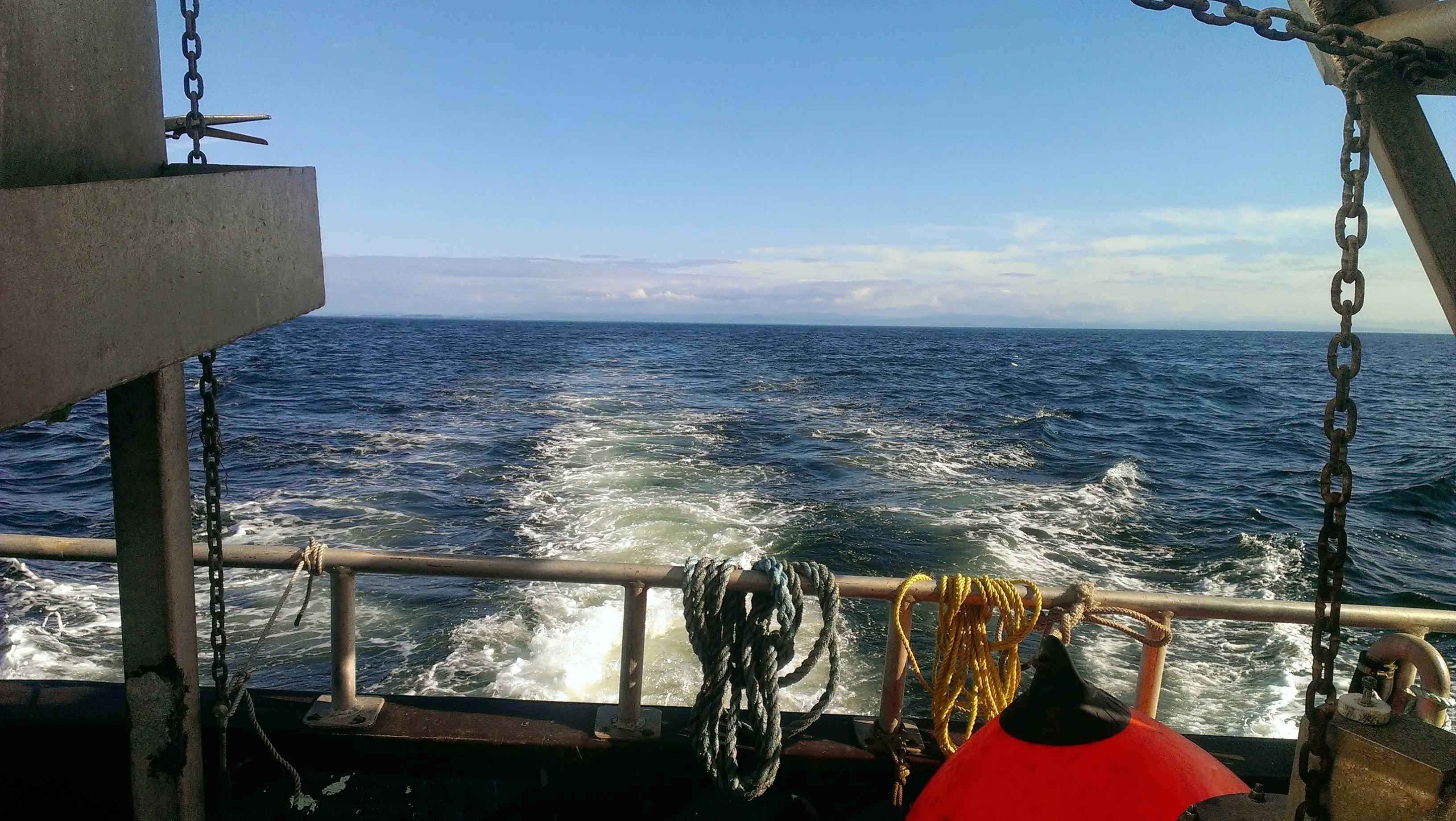 View over the stern of a working vessel with its wake across open water